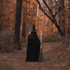 back view of woman in the woods wearing witch costume